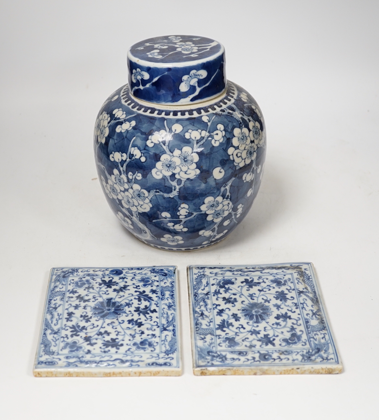 A 19th century Chinese blue and white prunus jar and cover, together with two similar tiles, jar 21cm